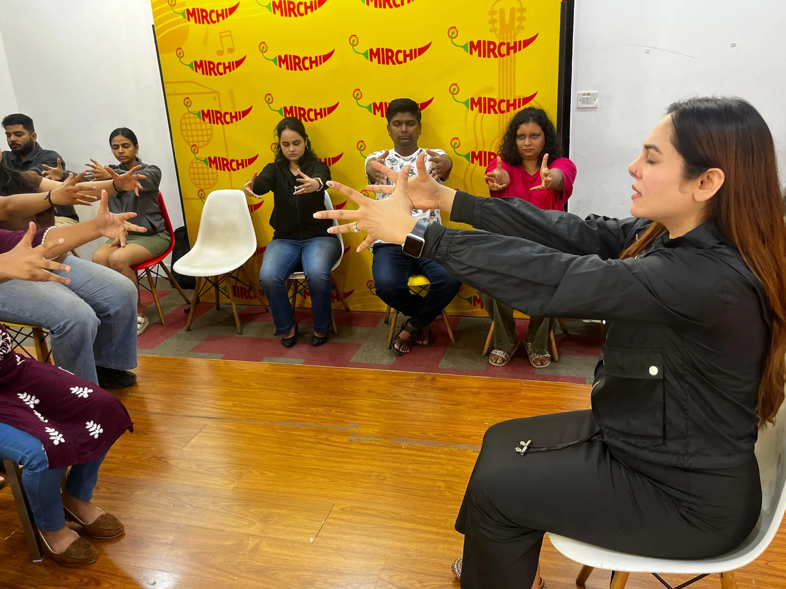 Vibha Jain leading a group healing workshop, guiding participants through a seated exercise