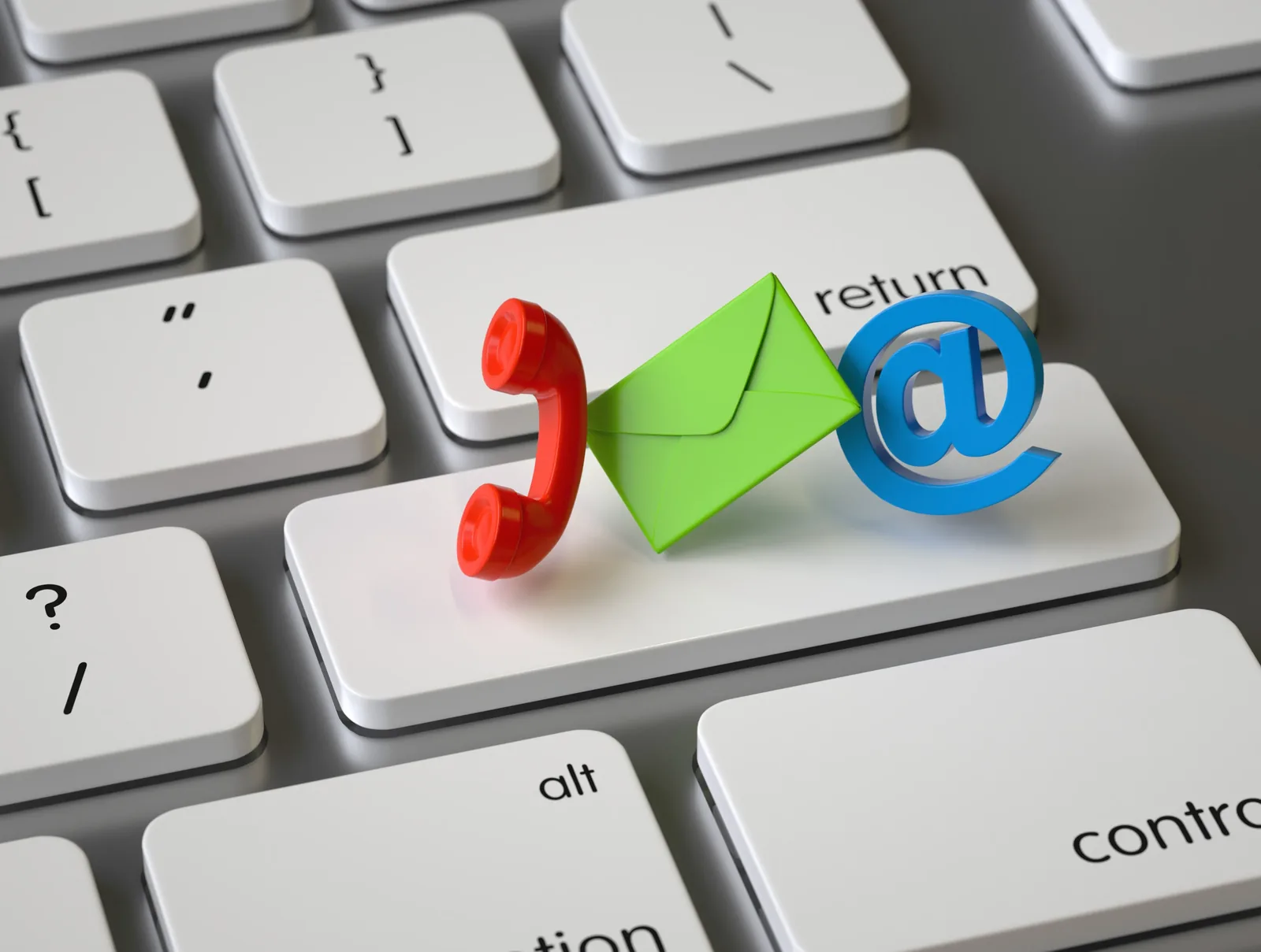 A keyboard with three-dimensional phone, envelope and at-sign icons representing email and phone support
