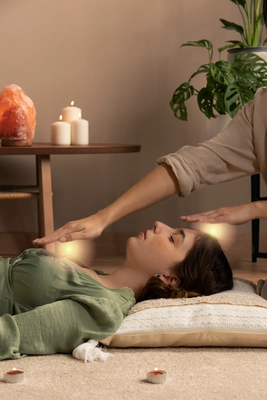 A person lying comfortably during a calm, supportive healing session with a practitioner nearby